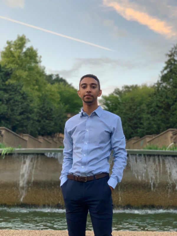 Elijah Catalan standing in front of vaporwave-esque art