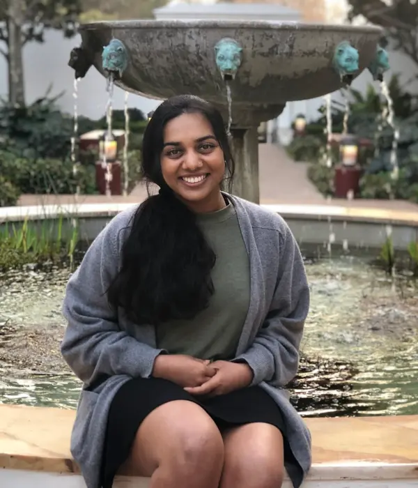 Ashley Fernando seated on the edge of a garden fountain