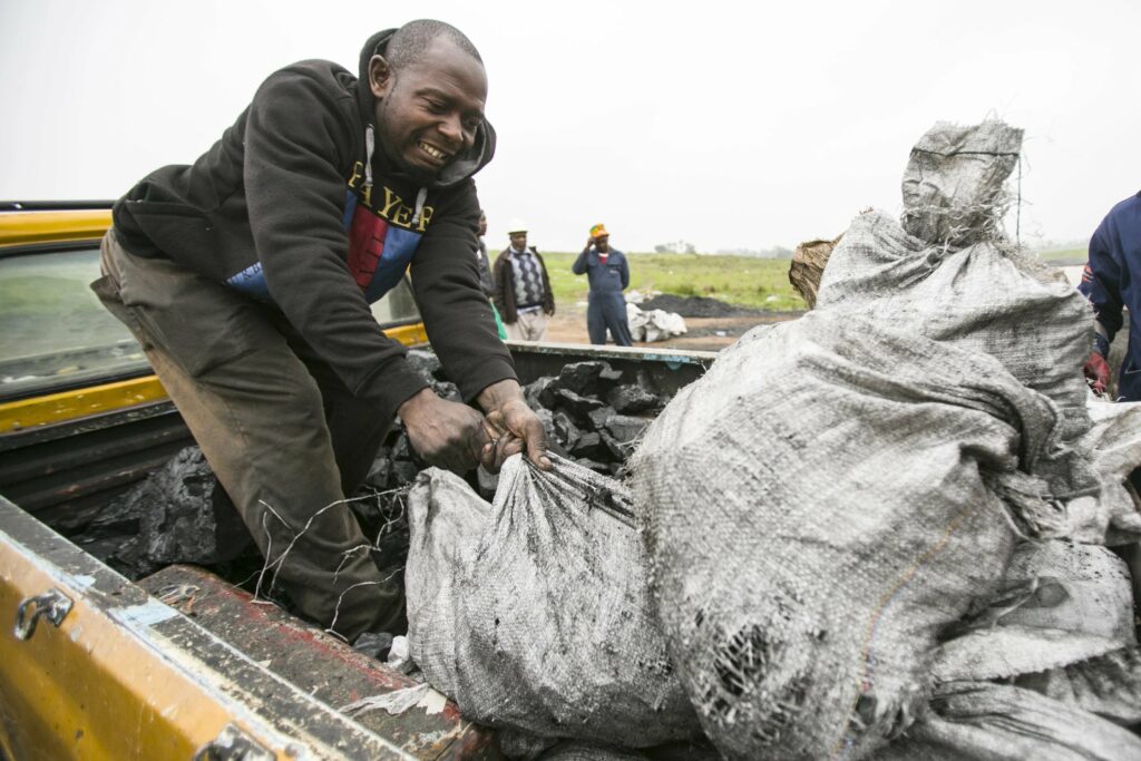 Man loading coal on truck from Emmy-winning episode.