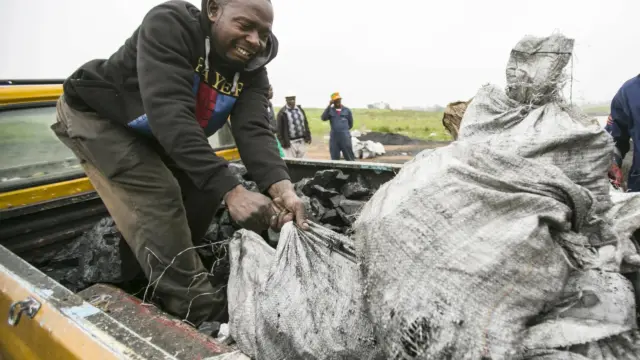 Man loading coal on truck from Emmy-winning episode.