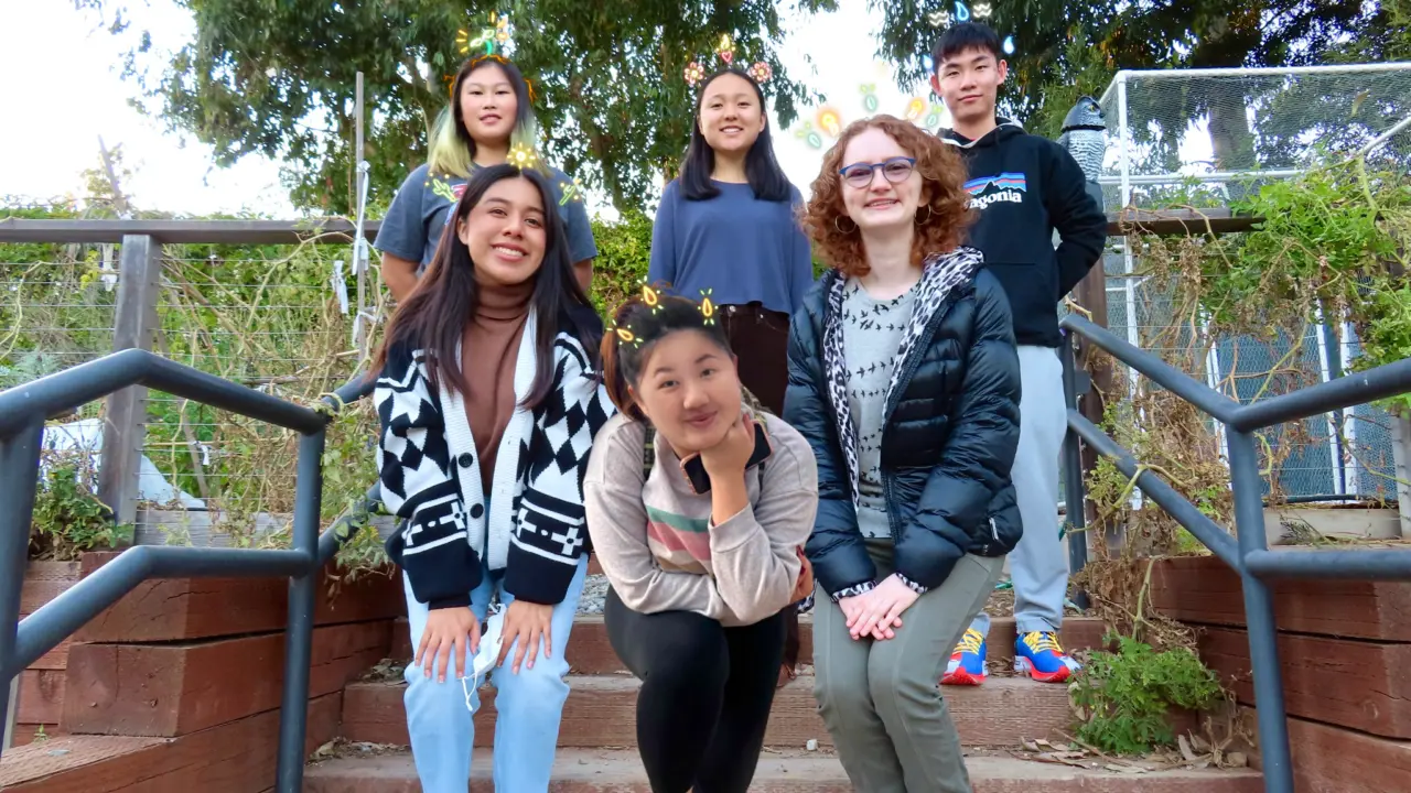 Six students in a garden.