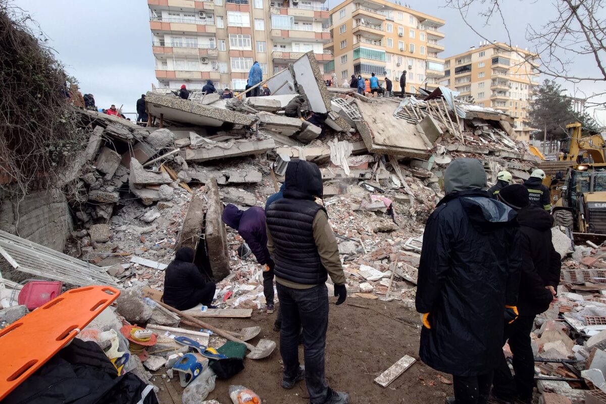 People looking at collapsed buildings in Turkey after the February 2023 earthquake