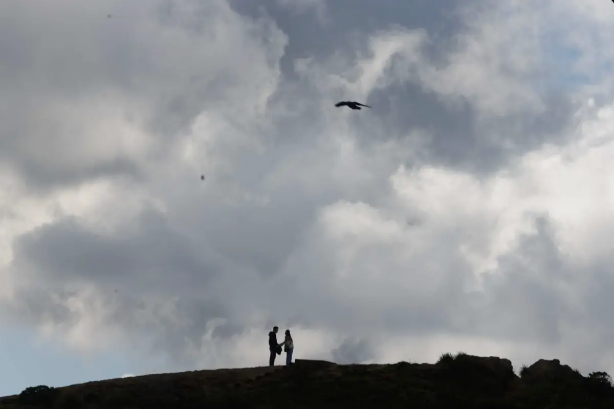 A couple are silhouetted under a cloudy peak as they hike at San Francisco’s Twin Peaks in March. Temperatures were below normal in California in 2023, thanks to an especially cold and wet winter. Lea Suzuki. The Chronicle 2023