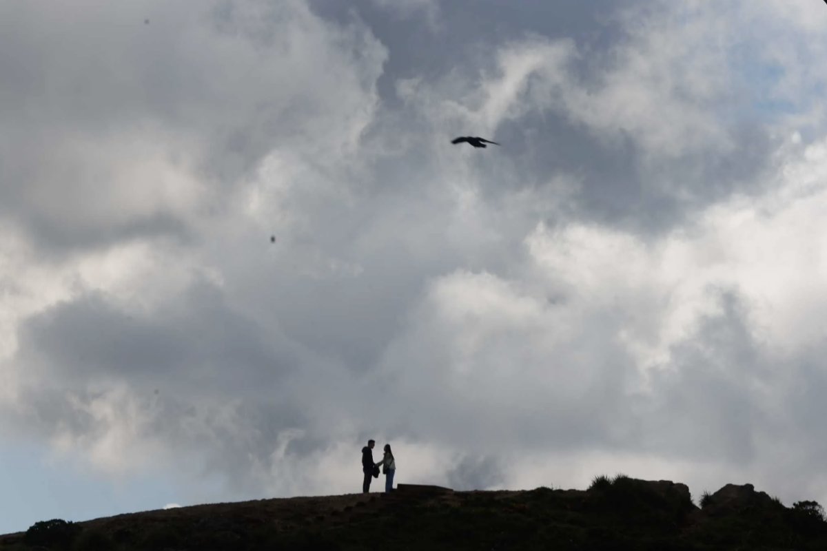 A couple are silhouetted under a cloudy peak as they hike at San Francisco’s Twin Peaks in March. Temperatures were below normal in California in 2023, thanks to an especially cold and wet winter. Lea Suzuki. The Chronicle 2023