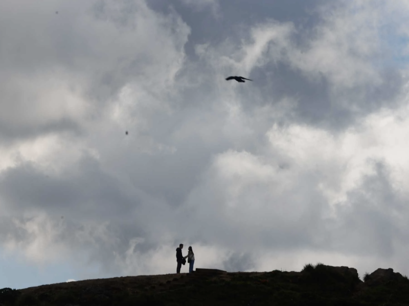 A couple are silhouetted under a cloudy peak as they hike at San Francisco’s Twin Peaks in March. Temperatures were below normal in California in 2023, thanks to an especially cold and wet winter. Lea Suzuki. The Chronicle 2023