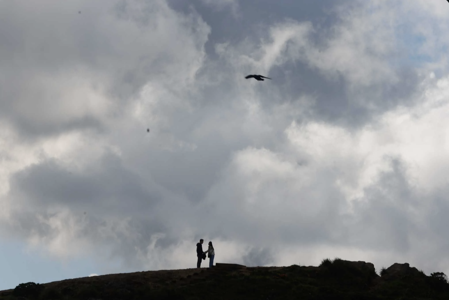 A couple are silhouetted under a cloudy peak as they hike at San Francisco’s Twin Peaks in March. Temperatures were below normal in California in 2023, thanks to an especially cold and wet winter. Lea Suzuki. The Chronicle 2023