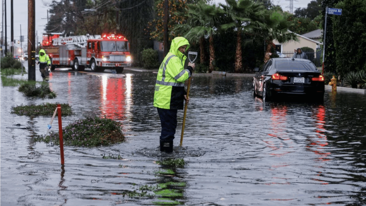 A man stands in flood water in Tarzana, in the San Fernando Valley region of Los Angeles, California, U.S. February 1, 2024. REUTERS/Carlin Stiehl