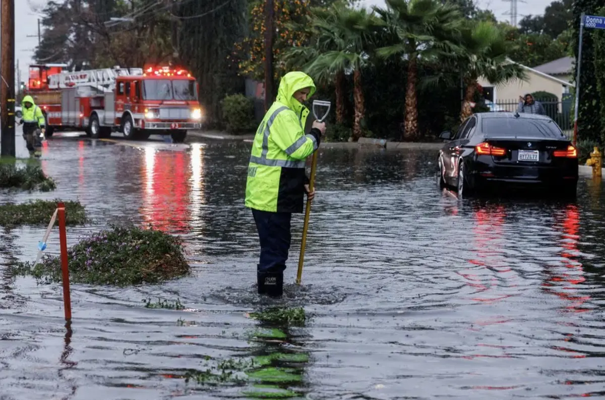 A man stands in flood water in Tarzana, in the San Fernando Valley region of Los Angeles, California, U.S. February 1, 2024. REUTERS/Carlin Stiehl