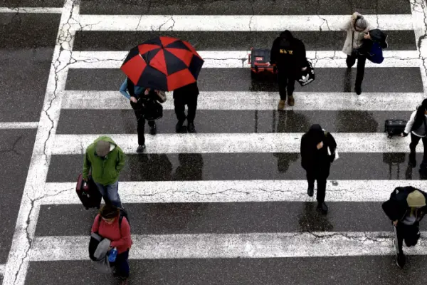 Travelers arrive at LAX in the rain last week. Another wet weather pattern is headed toward California, with rainfall expected through early next week. (Christina House / Los Angeles Times)