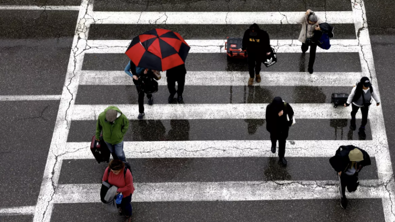 Travelers arrive at LAX in the rain last week. Another wet weather pattern is headed toward California, with rainfall expected through early next week. (Christina House / Los Angeles Times)