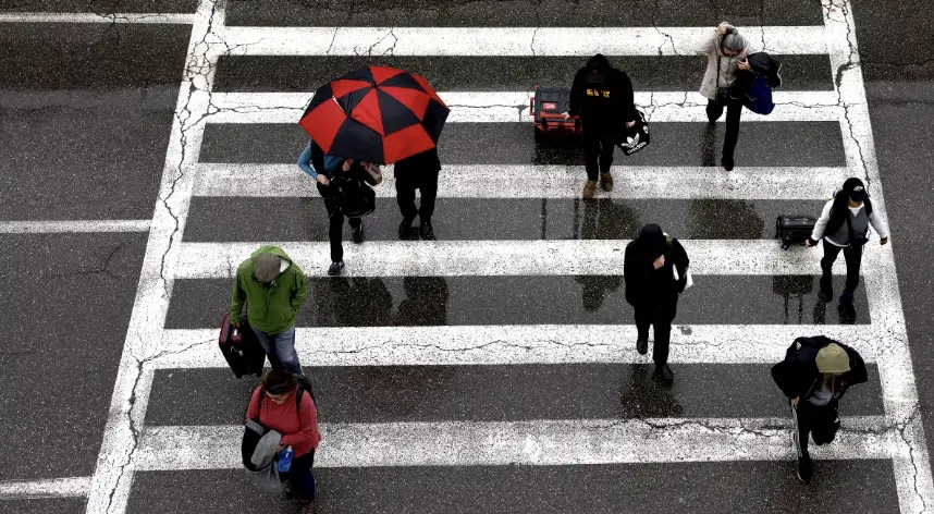Travelers arrive at LAX in the rain last week. Another wet weather pattern is headed toward California, with rainfall expected through early next week. (Christina House / Los Angeles Times)