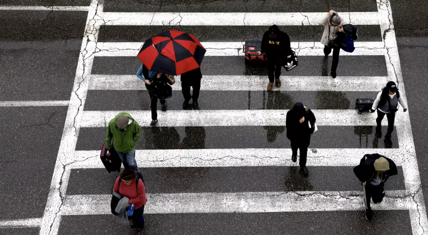Travelers arrive at LAX in the rain last week. Another wet weather pattern is headed toward California, with rainfall expected through early next week. (Christina House / Los Angeles Times)