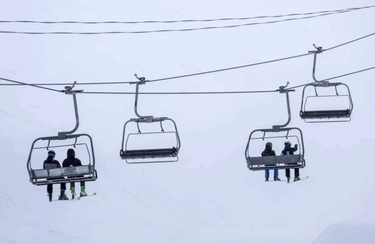 Skiers ride a chair lift on a blustery day at Mammoth Mountain on March 14 in Mammoth Lakes. (Brian van der Brug / Los Angeles Times)