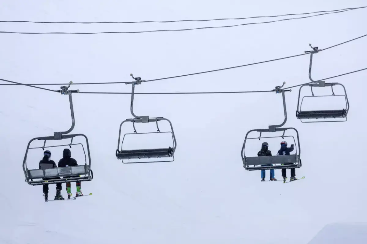 Skiers ride a chair lift on a blustery day at Mammoth Mountain on March 14 in Mammoth Lakes. (Brian van der Brug / Los Angeles Times)