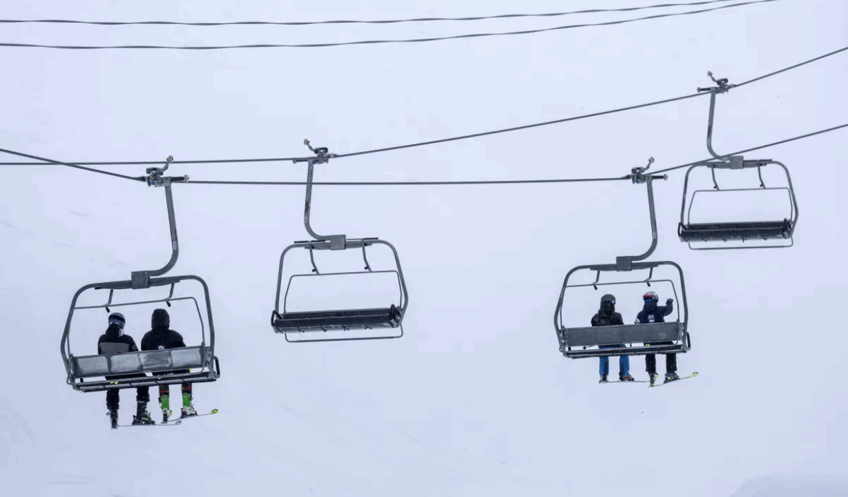Skiers ride a chair lift on a blustery day at Mammoth Mountain on March 14 in Mammoth Lakes. (Brian van der Brug / Los Angeles Times)