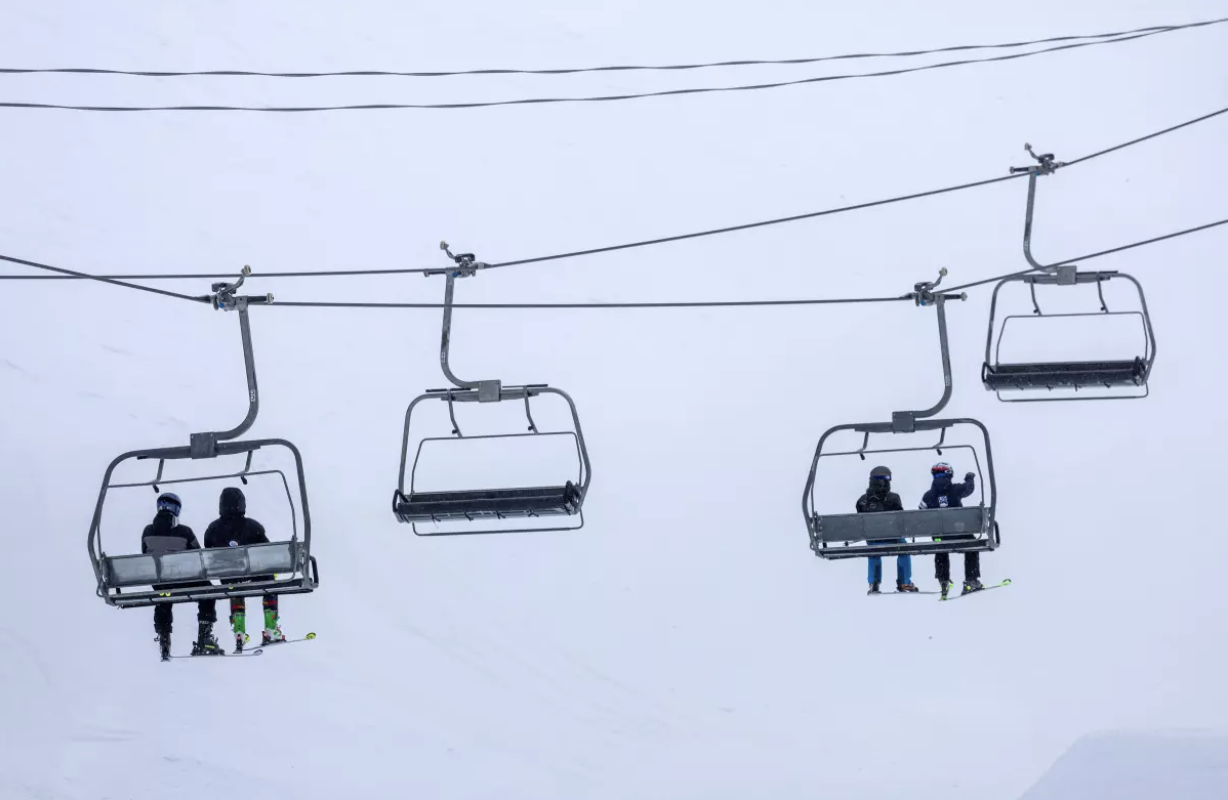 Skiers ride a chair lift on a blustery day at Mammoth Mountain on March 14 in Mammoth Lakes. (Brian van der Brug / Los Angeles Times)