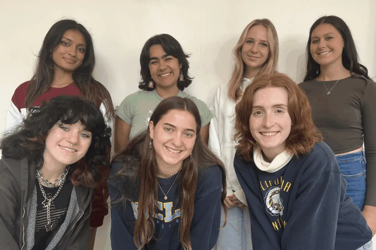 A group of seven UCLA students posing together indoors as members of the Zero Waste Communication team.