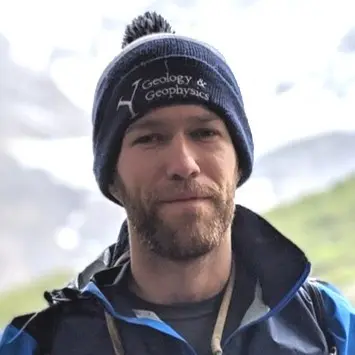 Ben Strong outdoors in a mountainous landscape.