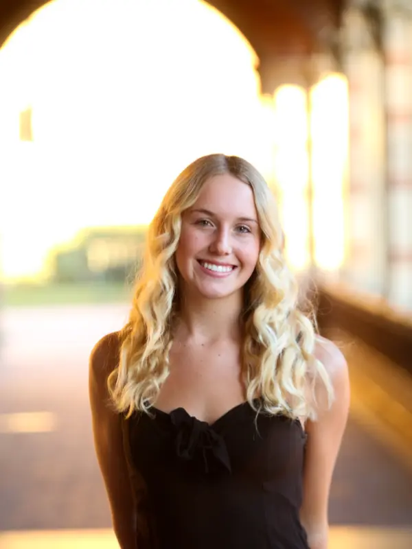 Pam Nelson, photographed in an arched campus walkway at sunset.