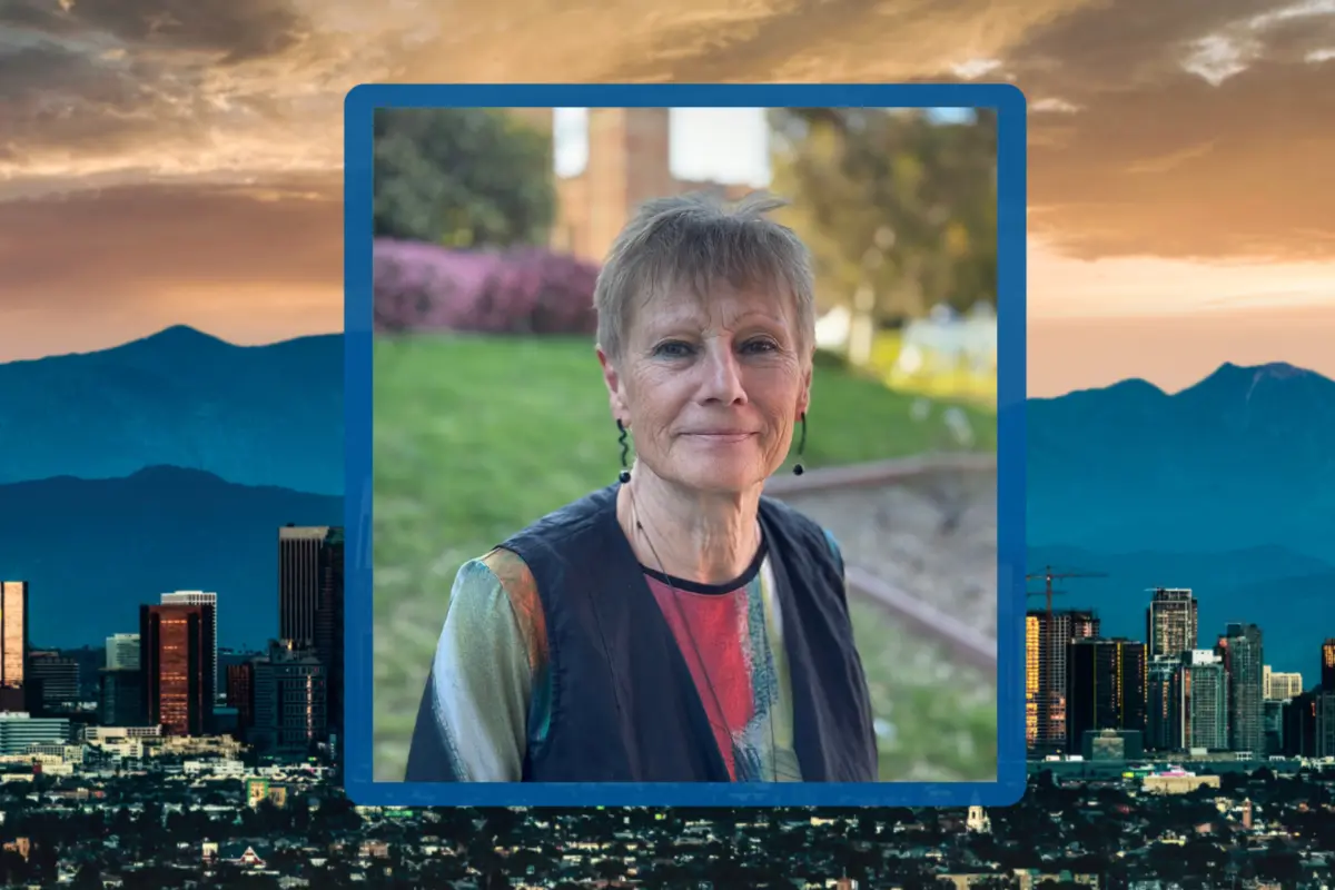 Portrait of Professor Ursula K. Heise on the UCLA campus, framed against a backdrop of the Los Angeles skyline at dusk.