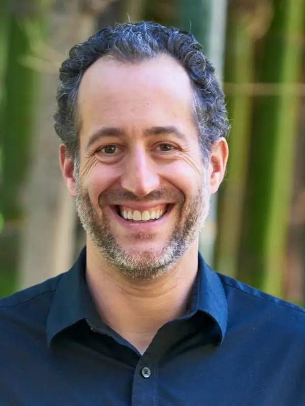 Kirk Lohmueller, outdoors in front of bamboo
