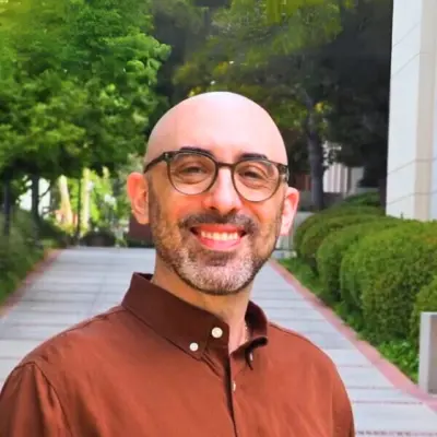 Benjamin Paul, outdoors on a tree-lined campus walkway