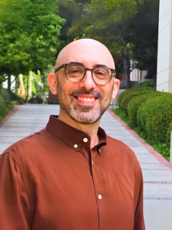 Benjamin Paul, outdoors on a tree-lined campus walkway