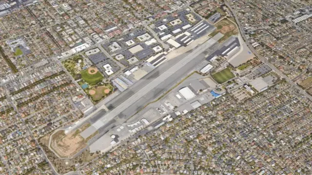Aerial view of Santa Monica Airport's single runway and hangars surrounded by dense residential neighborhoods.