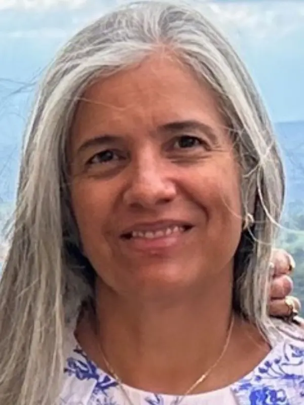 Mónica Medina outdoors with green hills in the background
