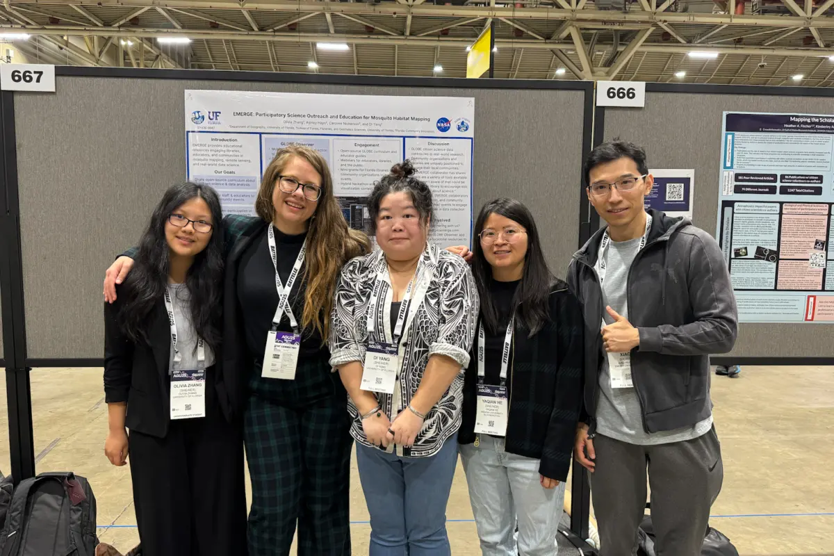 Five people pose in front of a poster at a research conference.