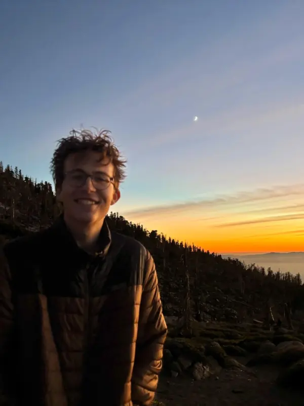 Tallis Arnold on a forested mountainside at sunset