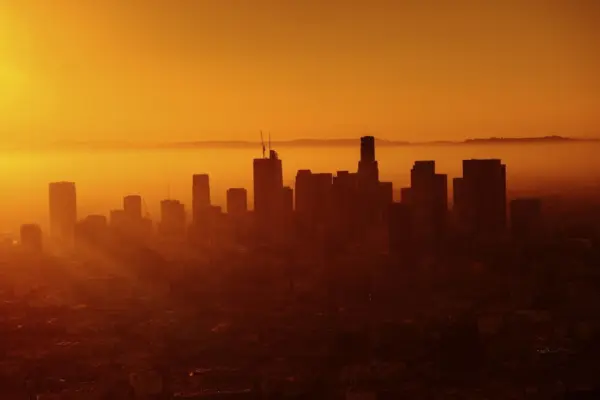 The sun rising on a big city with skyscrapers.