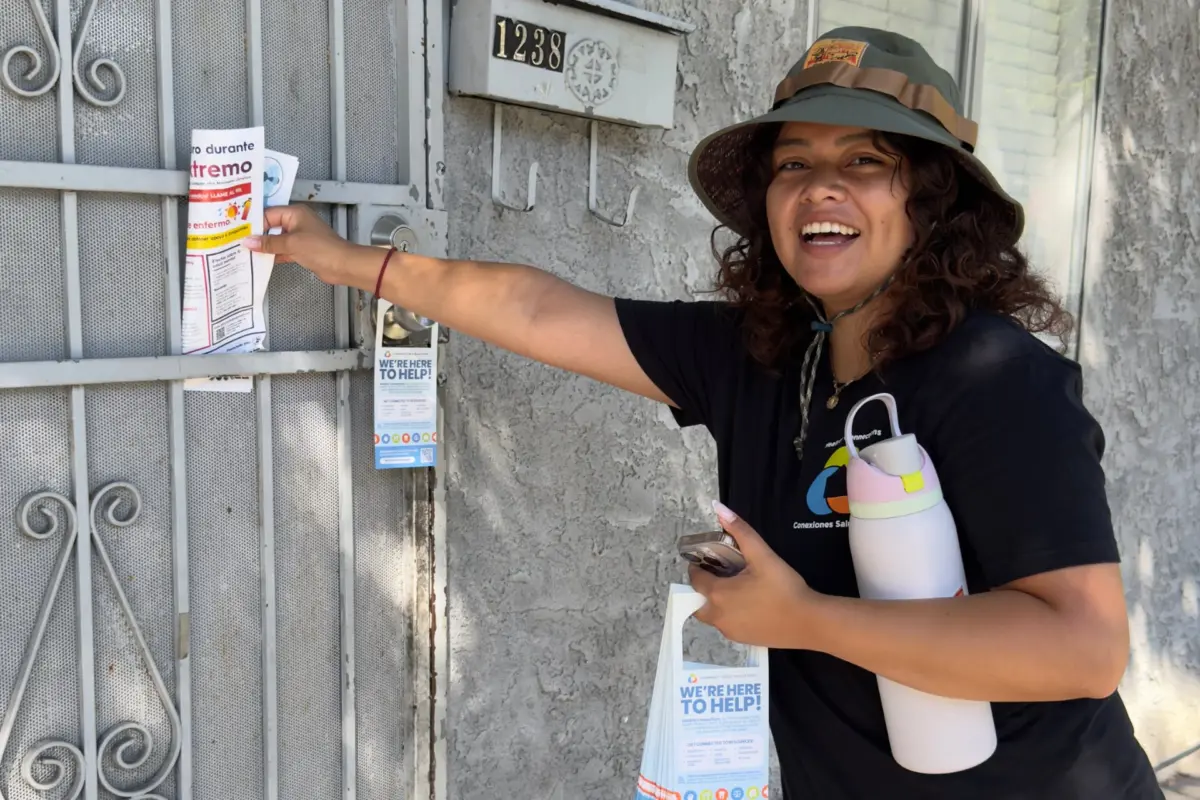 Volunteer hanging flyers on door front