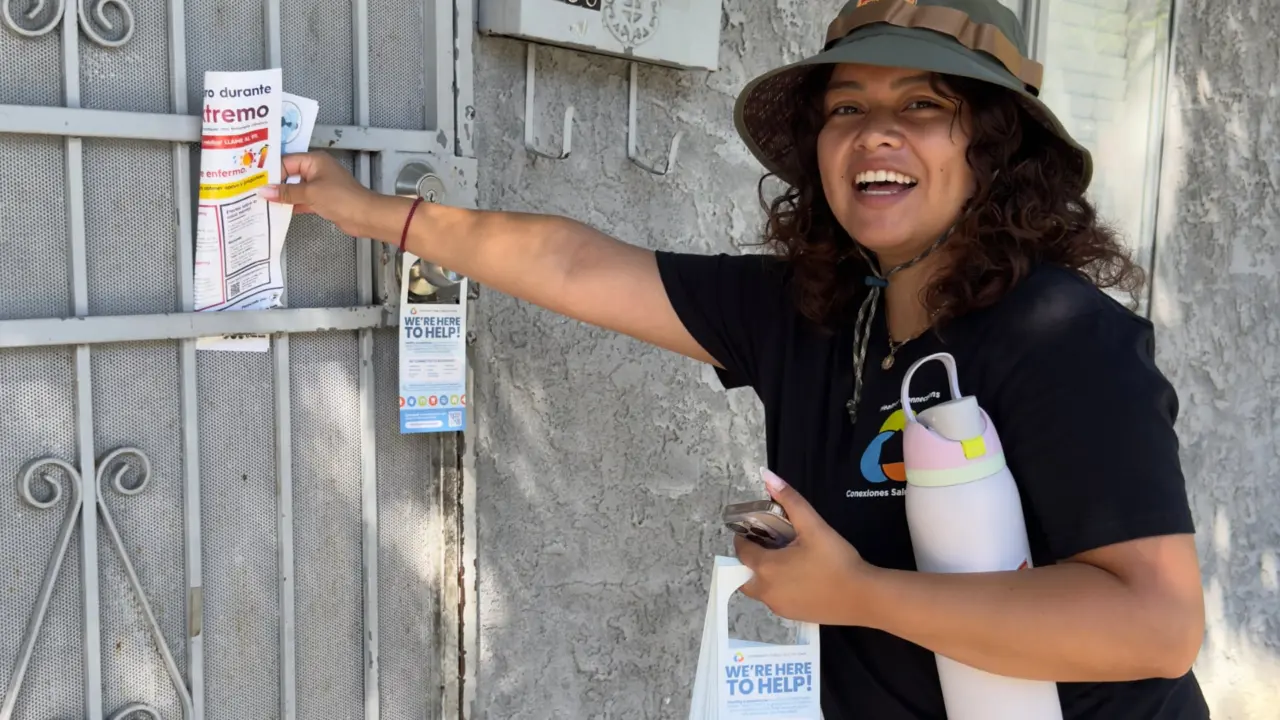 Volunteer hanging flyers on door front