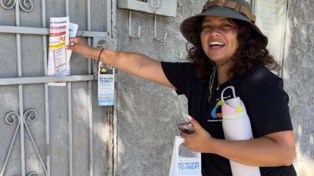 Volunteer hanging flyers on door front