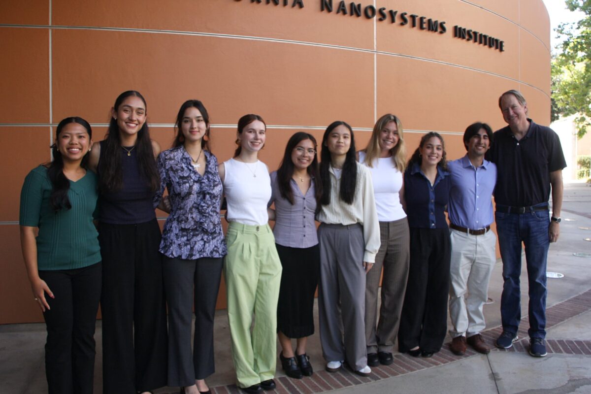 A group of students and their faculty adviser stand together outside the California NanoSystems Institute building at UCLA.
