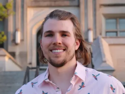 Devon DeRaad smiling in front of a building