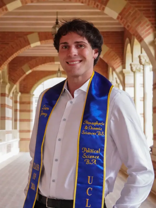 Liam Jenny wearing a UCLA graduation stole in a campus archway